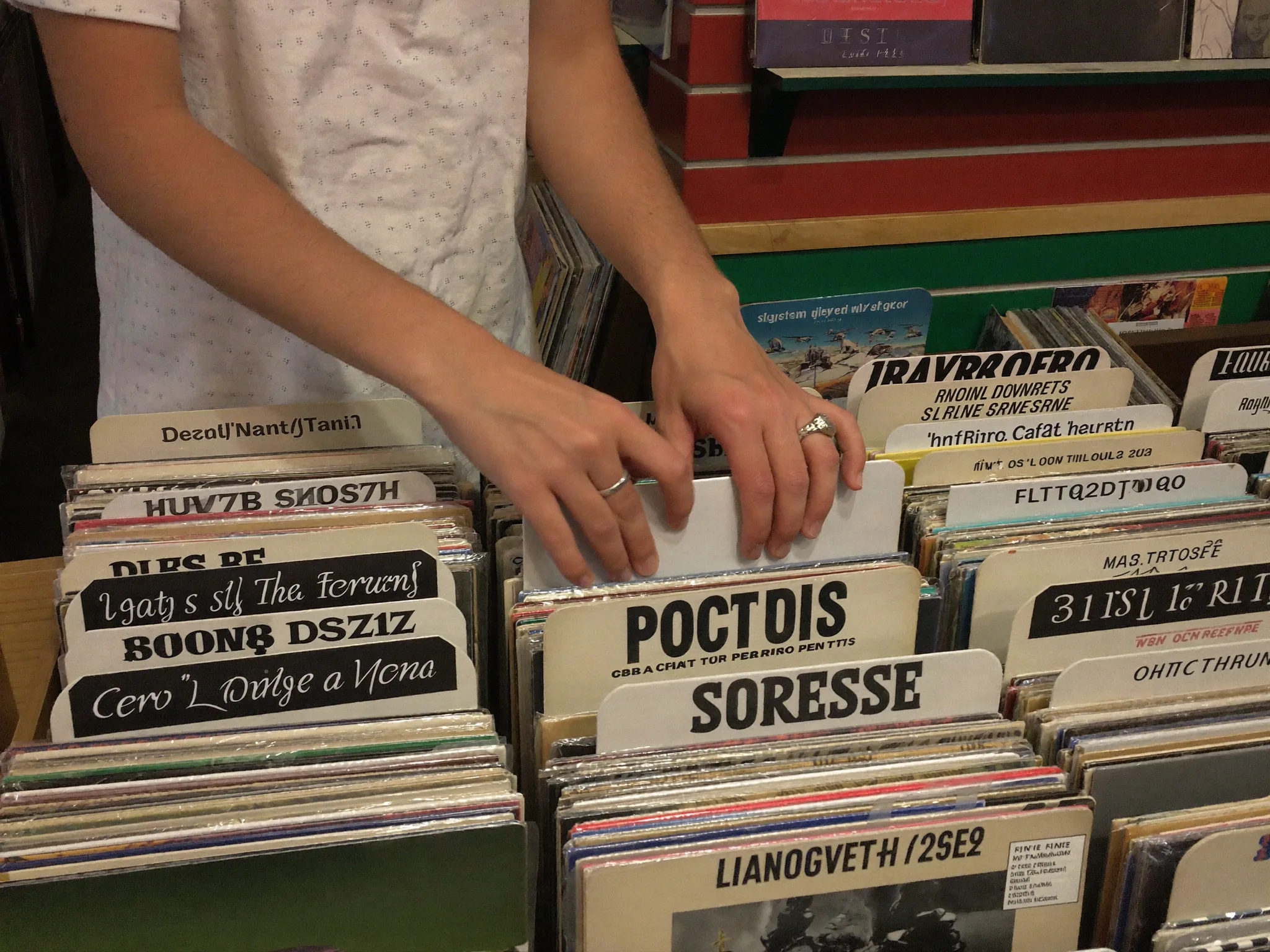 Hände blättern durch Schallplatten im Plattenladen